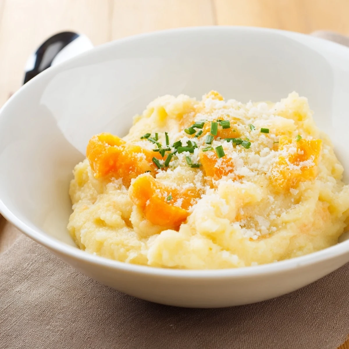 Creamy, rich, steaming bowl of Ultimate Creamy Potato Soup garnished with fresh chives.