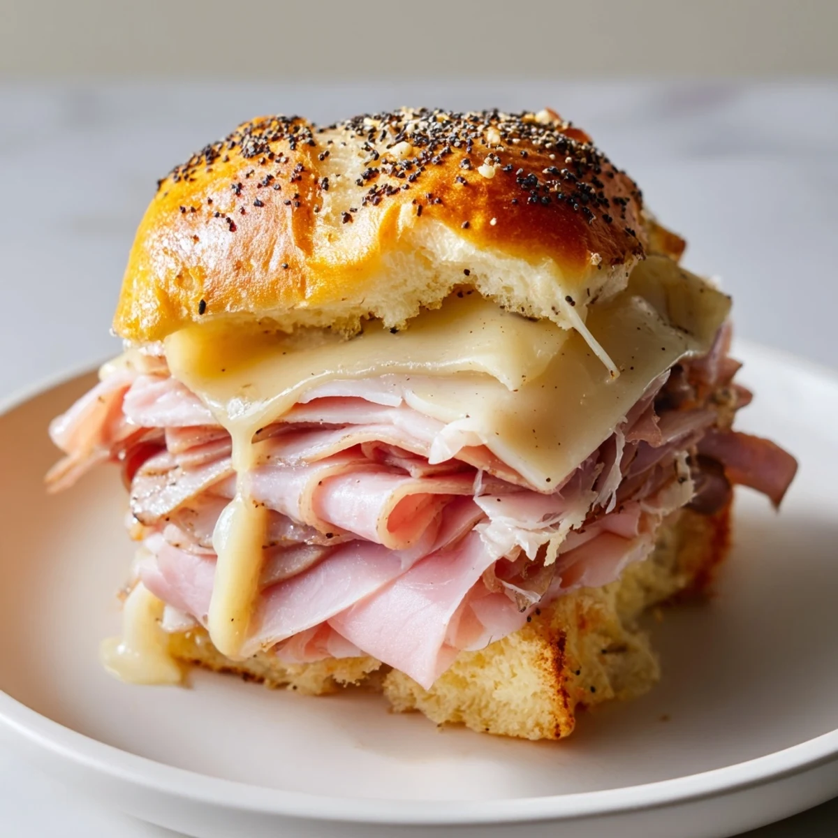 Twelve baked Budget-Friendly Ham & Cheese Sliders, showcasing layers of ham and cheese on pillowy slider buns.