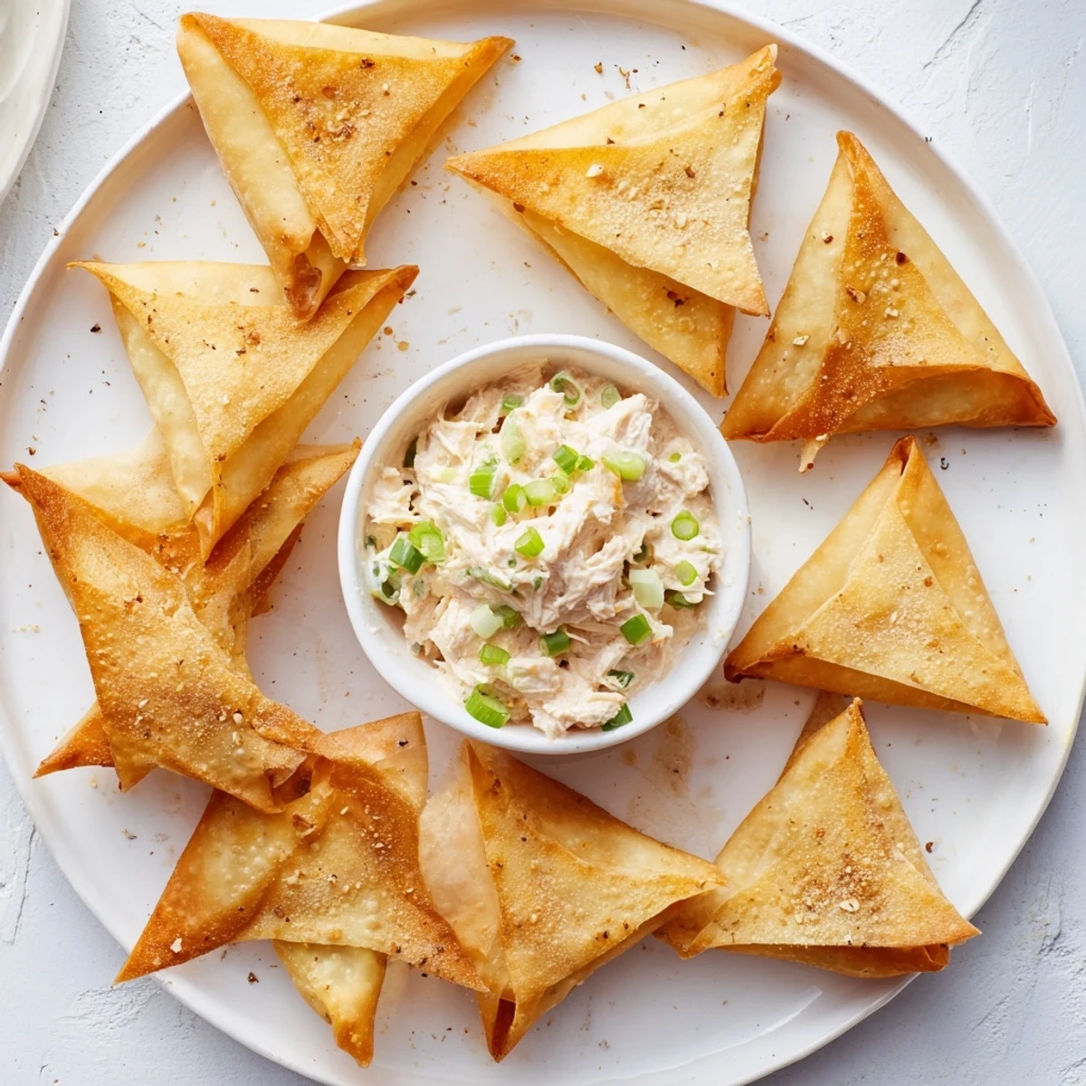 Freshly made air fryer lumpia chips, perfect for dipping into a flavorful chicken and cream cheese dip.
