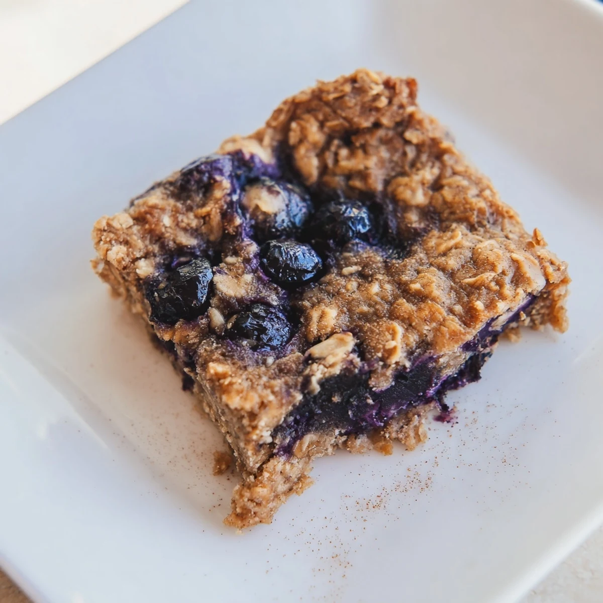 Freshly baked Blueberry Banana Oatmeal Protein Bars with glistening blueberries, ready to eat.