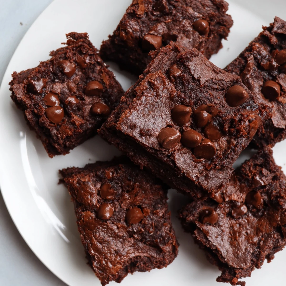Warm, fudgy Greek yogurt brownies topped with melted chocolate chips, a delicious dessert ready to eat.