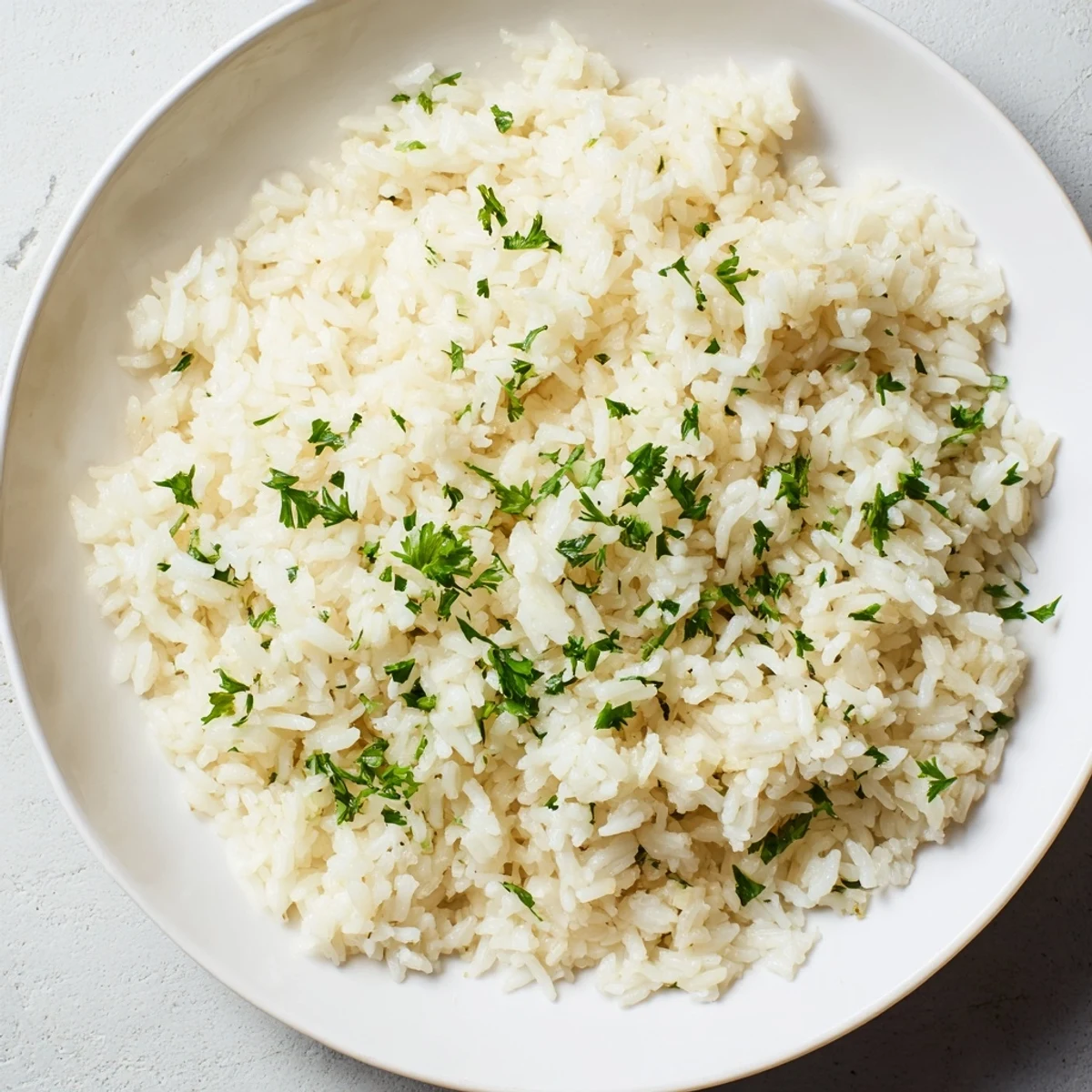 This perfect batch of Garlic Butter Rice, easy and gluten-free, with a garnish of fresh parsley.