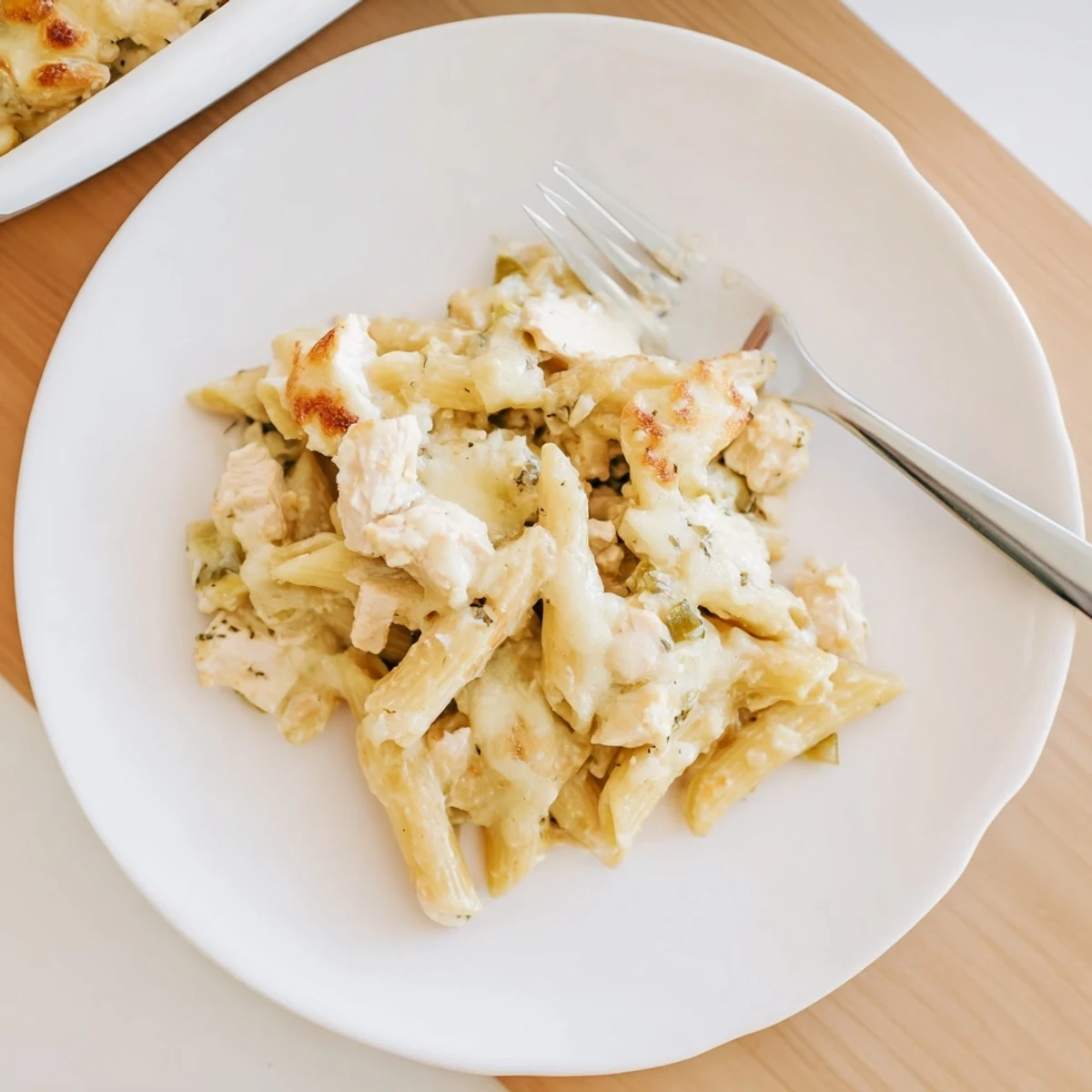 Family-style Chicken Alfredo Casserole in a dish, steam rising from melted cheese, perfect for a comforting weeknight dinner.