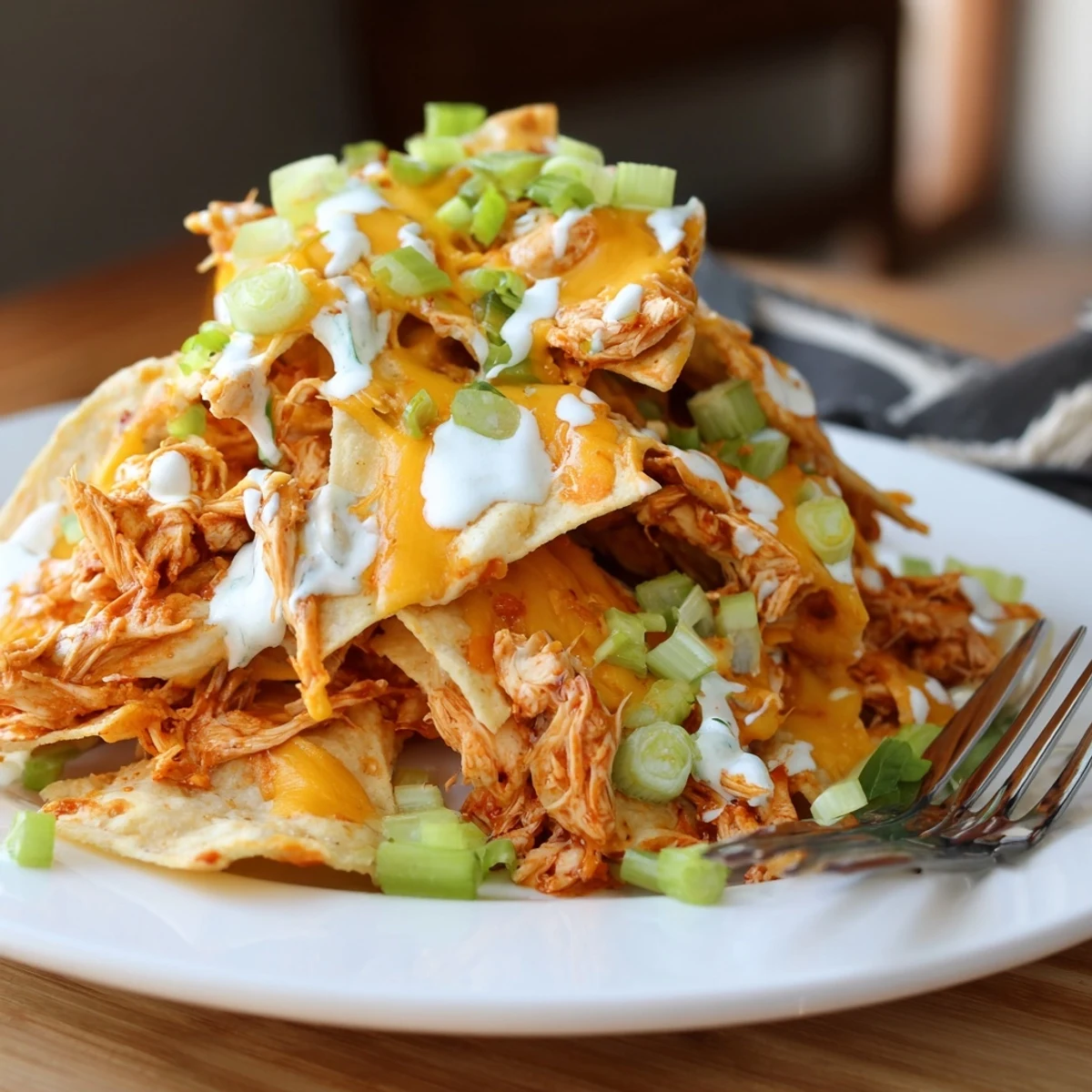 Golden melted cheese on Buffalo Chicken Nachos with a cool ranch drizzle and vibrant cilantro garnish.