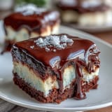 White chocolate buttercream graduation cake with dramatic ganache drip and festive edible gold balloons, ideal for milestone parties.