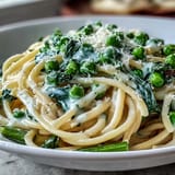 Spring pasta with lemon cream sauce and peas, featuring tender linguine and vibrant green vegetables.  