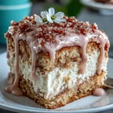 Pink rosé velvet cake glistening with cream cheese frosting and edible gold.