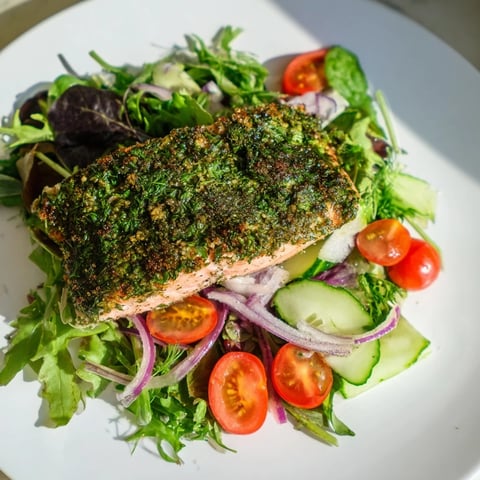 Warm, flaky herb-crusted salmon salad with bright cherry tomatoes and a tangy dressing.