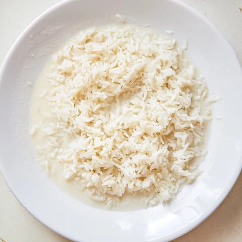 Fluffy Coconut Jasmine Rice with fragrant steam, ideal with a flavorful Thai curry dinner.