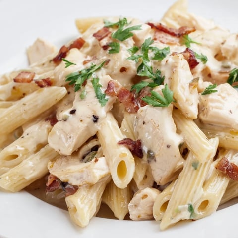 Creamy Chicken Bacon Penne pasta tossed in a rich garlic-Parmesan sauce, topped with crispy bacon bits and fresh parsley garnish.