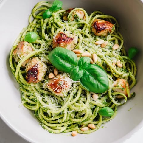 Juicy, golden chicken strips mingle with crisp zucchini noodles in this vibrant Pesto Zucchini Chicken Bowl, garnished with Parmesan and pine nuts.