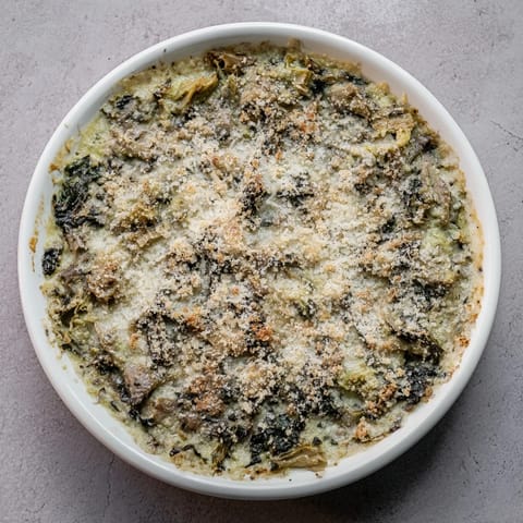 A close-up of a warm, cheesy Baked Spinach and Artichoke Dip, inviting and delicious.