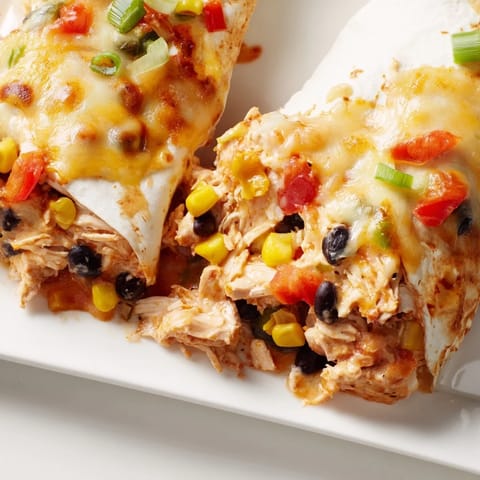 A close-up of a cheesy Taco Bell Copycat Chicken Bake, showing the layers of chicken and tortillas.