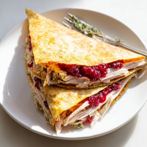 Savory Turkey, Stuffing & Cranberry Leftovers Tortilla Wrap, ready to eat with a drizzle of gravy next to it.