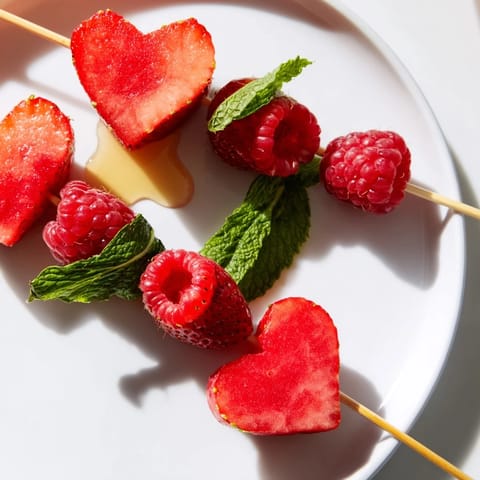 Fresh heart-shaped strawberry and watermelon red heart fruit skewers, ready to enjoy immediately.