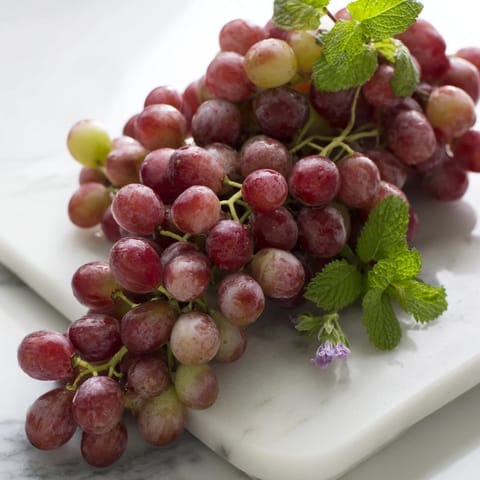 Fresh, juicy grapes spilling over a board, a visually stunning appetizer for your next gathering.