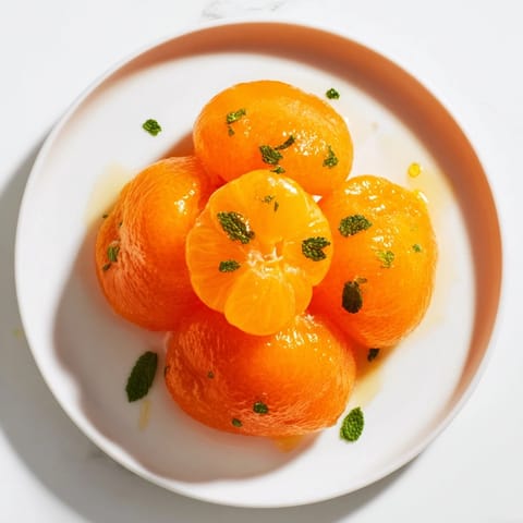 A close-up of a colorful clementine and mint winter fruit salad, beautifully presented and ready to serve.