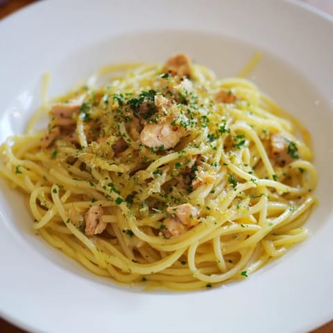 A close-up of Simple Garlic Butter Bucatini, showing cooked pasta and shredded chicken topping.