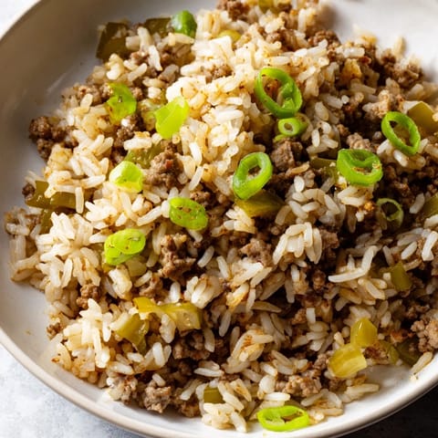 Ground meat and vegetables simmered with spices for an appetizing Cajun Dirty Rice recipe image.