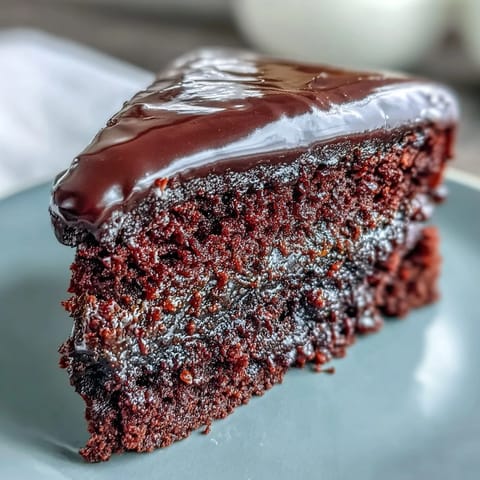 Rich Easy Chocolate Fudge Cake served with a dollop of whipped cream and fresh raspberries. 