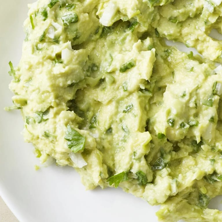 Vibrant avocado lime dip in a white bowl, surrounded by colorful crudités, perfect for a summer appetizer spread.