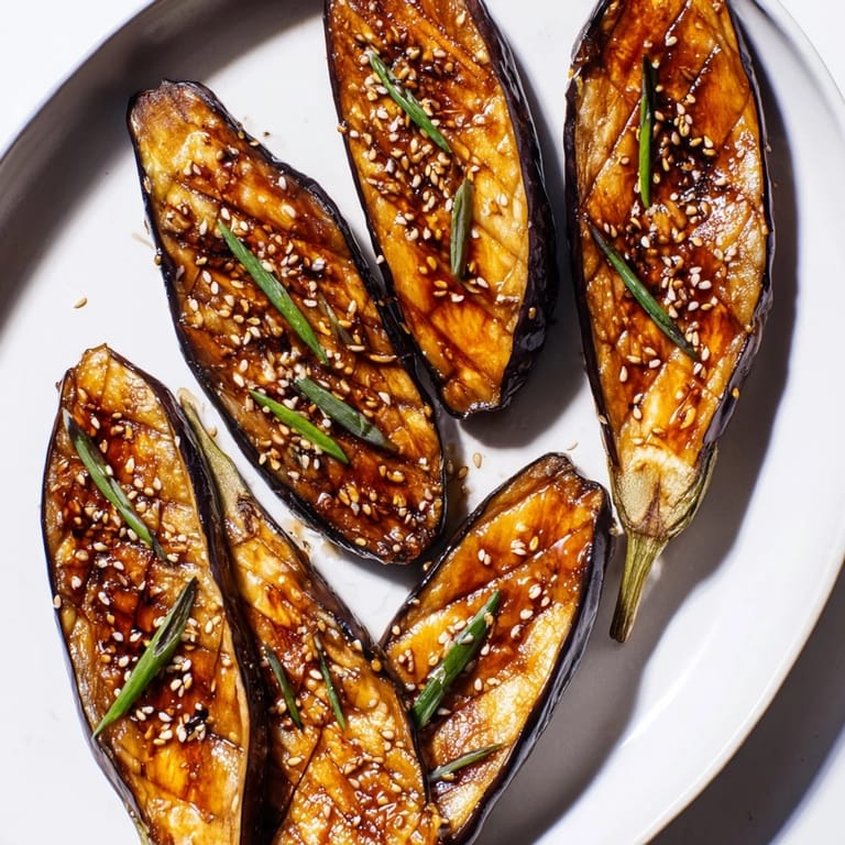 Tender, silky eggplant roasted to perfection with a sticky, broiled miso glaze, creating a delicious vegan main or side dish.