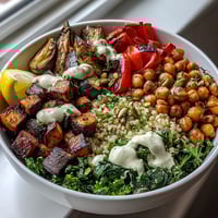 Mediterranean Buddha Bowl Meal Prep features bulgur pilaf with pistachios, roasted eggplant, and steamed kale, drizzled with creamy tahini dressing for a vibrant, healthy lunch.