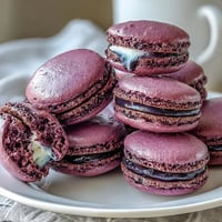Elegant blackcurrant macarons with smooth purple ganache between crisp almond shells, perfect for tea time or celebrations.