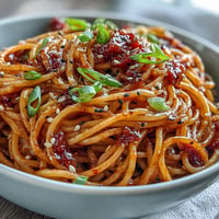 Creamy gochujang butter pasta with rich garlic sauce, garnished with sliced spring onions and sesame seeds.  